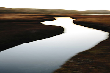 The open spaces of marshland and water channels. Flat calm water.