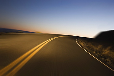 A blurred view of a road as a car drives on a highway just before sunrise, United States of America