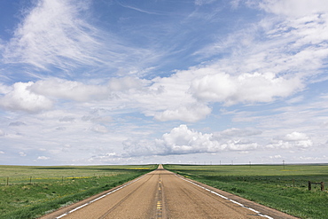 Open road through vast prairie and farmland, Saskatchewan, Canada