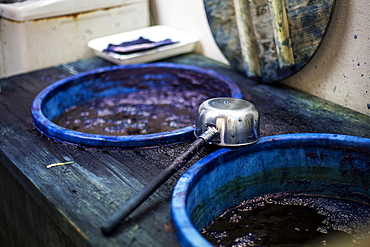 High angle close up of ladle and buckets with blue dye in a textile plant dye workshop, Kyushu, Japan