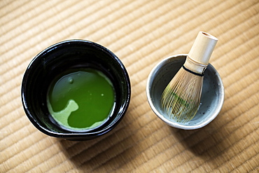 Tea ceremony utensils including bowl of green Matcha tea and bamboo whisk, Kyushu, Japan