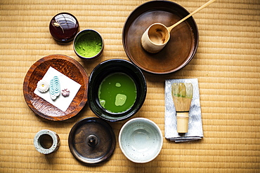 Tea ceremony utensils including bowl of green Matcha tea, a bamboo whisk and Wagashi sweets, Kyushu, Japan