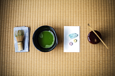 Tea ceremony utensils including bowl of green Matcha tea, a bamboo whisk and Wagashi sweets, Kyushu, Japan