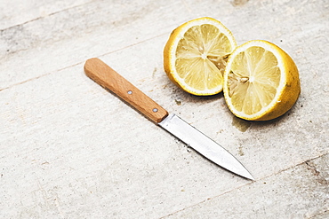 High angle close up of kitchen knife and fresh lemon sliced in half, Oxfordshire, England