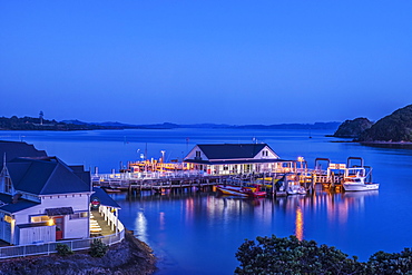 Illuminated building on water at dawn, Bay of Islands, Paihia, New Zealand