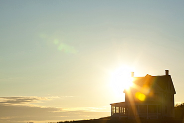 Sun shining behind rural house, Coupeville, Washington, USA