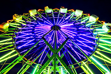 Neon Ferris Wheel ride at amusement park at night, Puyallup, Washington, USA