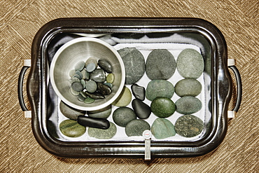 Hot stones and warmer on tray in spa