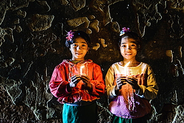 Asian girls holding candles in temple