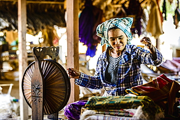 Asian woman spinning thread