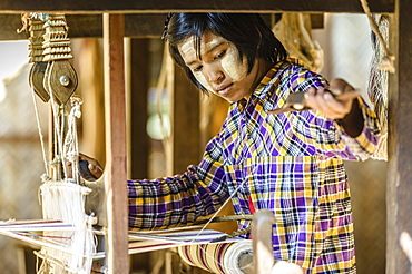 Asian girl weaving fabric