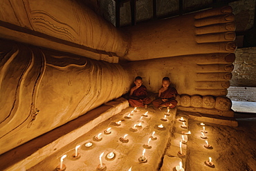 Asian monks lighting candles in temple