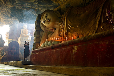 Asian monk lighting incense in temple