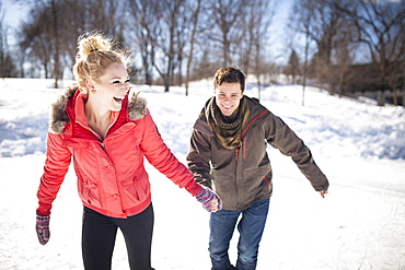 Caucasian couple ice skating on frozen lake