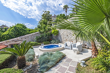 Soaking pool and armchairs on hillside patio