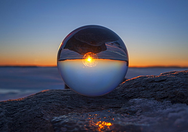 Close up of sunset horizon inverted in glass sphere