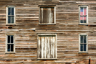 Wooden house exterior with American flag in window