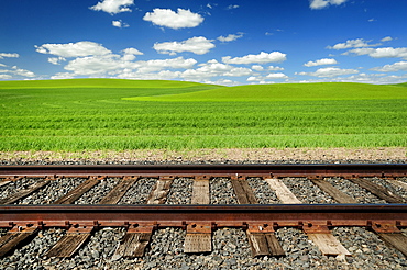 Railroad tracks and rolling hills in rural landscape