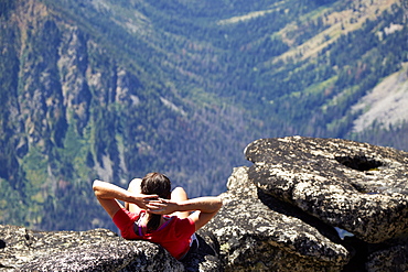 Hiker sitting on rocky hilltop, Leavenworth, Washington, USA