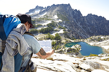 Mixed race man reading map on hilltop, Leavenworth, Washington, USA