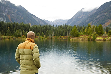 Hiker admiring lake and remote landscape, North Bend, Washington, USA