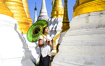 Asian woman carrying parasol at temple, Mingun, Mingun, Myanmar