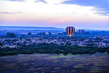 Hot air balloon flying over savanna landscape, Kenya, Africa