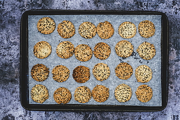 High angle close up of freshly baked seeded crackers on a baking tray, England