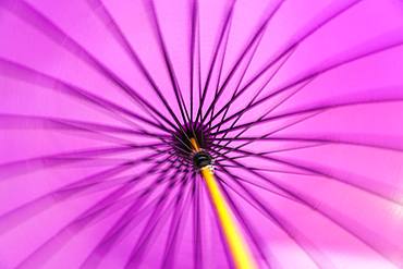 Motion blurred spinning close up of a traditional purple Japanese parasol or umbrella with a bamboo handle