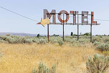 Vintage motel sign with dry scrub-land in foreground, Whitman County, Palouse, Washington, United States of America