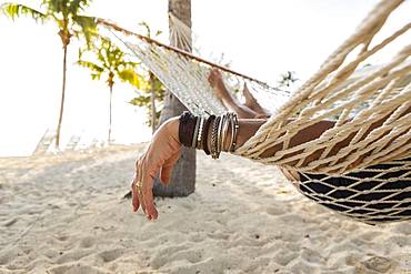 Close up of woman's arm and bracelets, relaxing resting in hammock , Grand Cayman, Cayman Islands