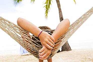 A teenage girl relaxing in a hammock, Grand Cayman, Cayman Islands