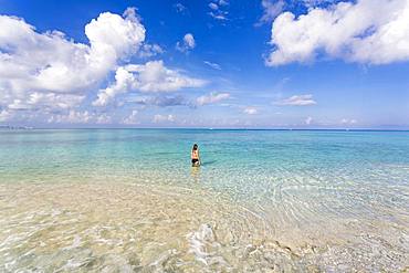 A teenage girl standing in the ocean, Grand Cayman, Cayman Islands