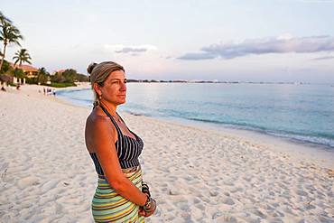 adult woman looking at setting sun, Grand Cayman, Cayman Islands