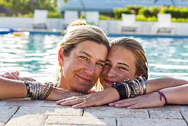 Mother and her 13 year old daughter in pool smiling, Grand Cayman, Cayman Islands