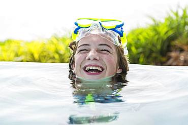 A teenage girl relaxing in a swimming pool, Grand Cayman, Cayman Islands