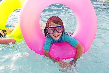 Siblings, brother and sister playing in pool with colorful floaties, Grand Cayman, Cayman Islands