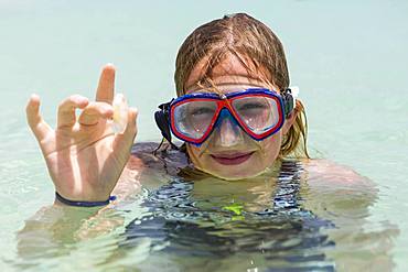 A teenage girl wearing snorkel mask holding sea glass, Grand Cayman, Cayman Islands