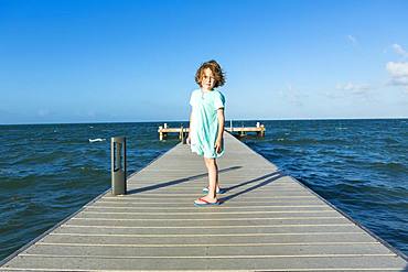 5 year old boy walking on a pier, view to the horizon, Grand Cayman, Cayman Islands