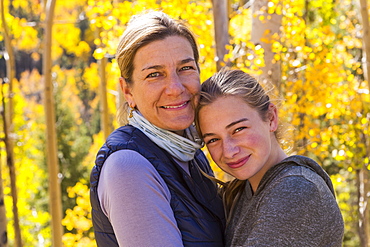 portrait of mother and her 13 year old daughter with autumn aspens in background