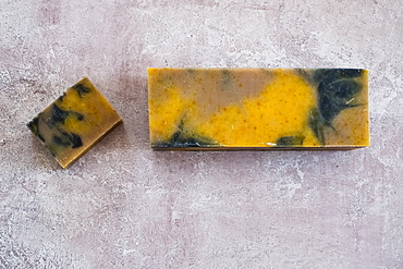 High angle close up of yellow and black homemade bar of soap