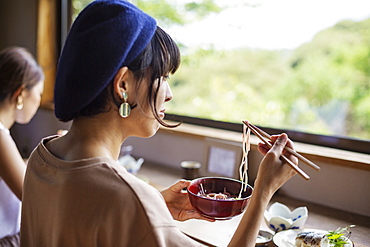 Two Japanese women sitting at a table in a Japanese restaurant, eating, Kyushu, Japan