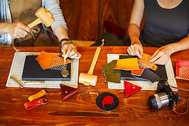 High angle view of two women sitting at a table, working in a leather shop, Kyushu, Japan