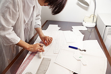 Japanese woman wearing glasses working at a desk in a small fashion boutique, Kyushu, Japan