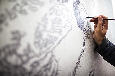 Close up of artist at work on a new painting in a studio, China