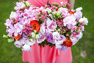 High angle close up of woman holding two bouquets of flowers with pink roses