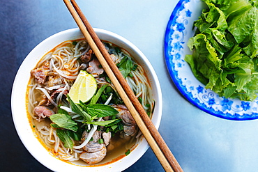 High angle close up of a bowl of bun bo hue, or beef noodle soup, Vietnam