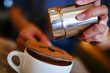 Close up of barista putting the finishing touches on a mocha, Vietnam