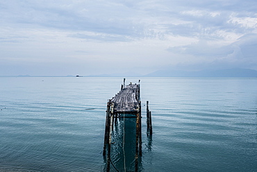 Seascape with old wooden jetty under a cloudy sky, Thailand