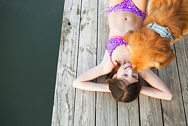 A young girl and a golden retriever dog on a jetty, Austin, Texas, USA